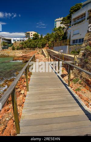 Wooden footbridge of the Salou coastal path surrounding the old lazaretto from 1829 (Tarragona, Catalonia, Spain) ESP: Pasarela de madera en Salou Stock Photo