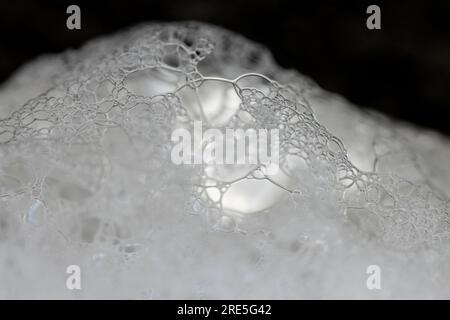 Soap bubble foam macro on black background. White soft foam Stock Photo
