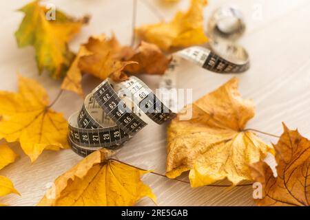 dry autumn leaves and measuring tape Stock Photo