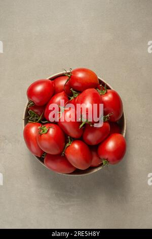 Culinary background. Tomatoes in a plate, spices and oil on a gray background Stock Photo