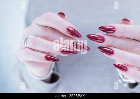 Premium Photo | A woman's hands with a dark colored nail polish and a ring  on the left hand.