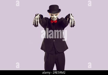 Skeleton man in Halloween costume looks ominously at you while standing in zombie pose. Stock Photo