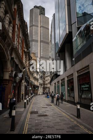 London, UK: People walking along Throgmorton Street in the City of London. View towards Tower 42. Stock Photo