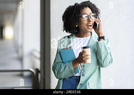 Pretty young black woman employee have phone call Stock Photo