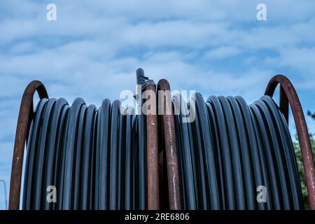 Cable drum containing a black cable Stock Photo
