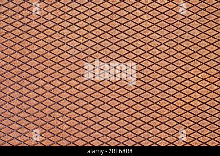 Perfectly geometric rhomboid pattern in rusty color on an empty metal plate, a sheet of non-slip iron material. Stock Photo