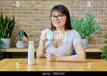 Middle aged woman drinking fermented milk product from bottle Stock Photo