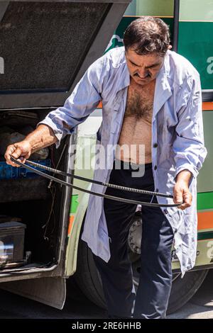 GABROVO, BULGARIA - JULY 27, 2019: Bus driver repairig his bus in Gabrovo town, Bulgaria Stock Photo