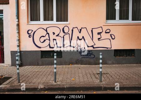 an ironic graffiti of the word 'crime' on a building wall in Sofia, Bulgaria Stock Photo