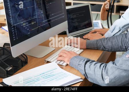 Male programmers working at table in office, closeup Stock Photo