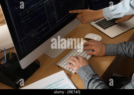 Male programmers working at table in office, closeup Stock Photo