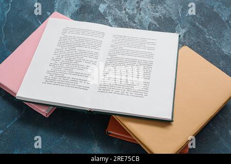 Open and closed books on dark blue table Stock Photo