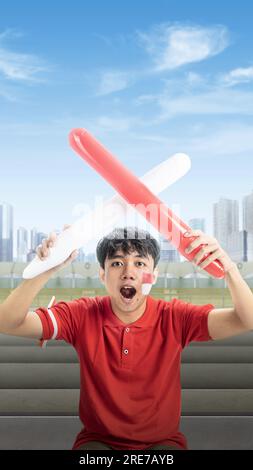 Indonesian man supporting the team when competing. Indonesian independence day Stock Photo