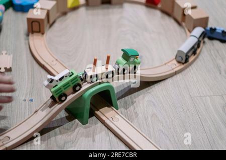 Wooden toy train playing in a hardwood floor playground Stock Photo