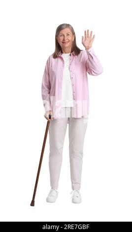 Senior woman with walking cane waving on white background Stock Photo ...