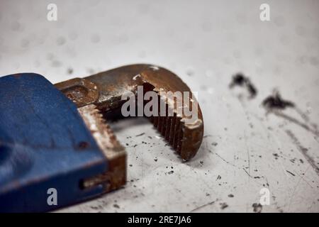 Close up of old rusty pipe wrench jaws on the working table. Stock Photo