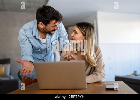 Couple of young designers working at modern home office, two coworkers discussing fun project Stock Photo