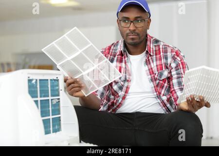 man having difficulty assembling air conditioning unit Stock Photo