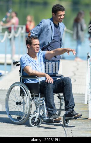 man in a wheelchair with beautiful view on the sea Stock Photo