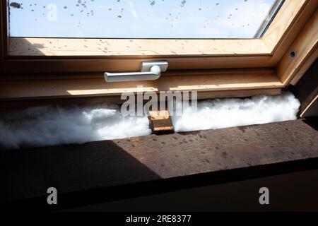 Fiberglass Cavity Insulation around Attic Window, UK Stock Photo