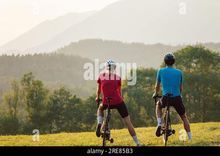 Man and woman couple road cycling on race bike outdoor in nature Stock Photo