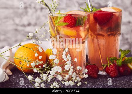 Aesthetic refreshing cocktails with citrus fruits and strawberries close up. Vitaminized summer detox water. Low-alcohol drinks without resistance dec Stock Photo