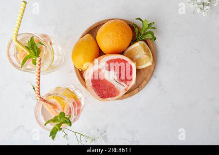 Top view of summer aesthetic fresh drink with citrus. Lemon, grapefruit, orange, mint. Detox vitaminized water. Low alcohol, hard seltzer, zero proof Stock Photo