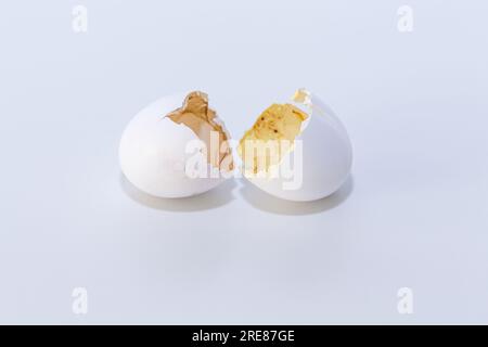 Broken white eggshell on clean bright background representing new life and fresh start. Stock Photo