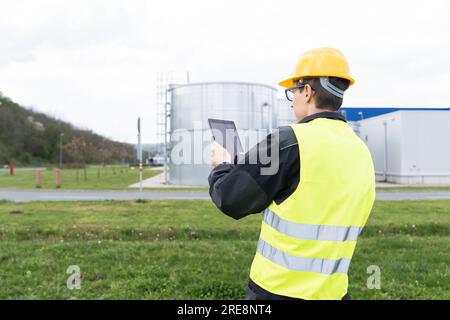Engineer with digital tablet on a background of gas tanks. Stock Photo