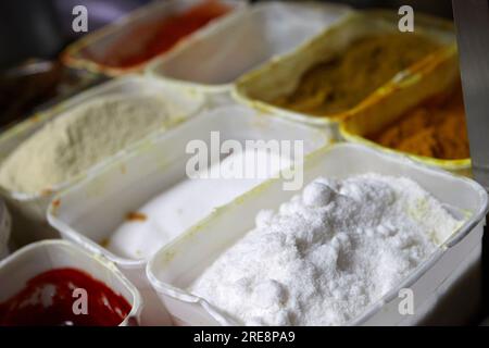 containers of spices and sauces ready for cooking in an indian restaurant Stock Photo