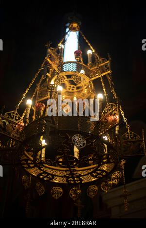 Golden chandelier in temple. Interior of Orthodox Church. Large antique chandelier. Beautiful piece of furniture. Stock Photo