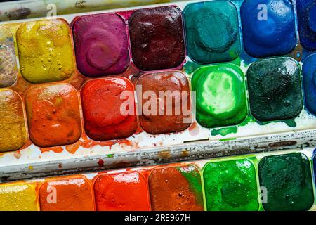 Top view of palette of colorful bright used aquarelle paints as abstract textured background Stock Photo