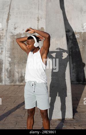 Confident African American runner warming up and doing stretching exercise while preparing for active training Stock Photo