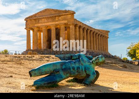 Bronze statue of Icarus in front of the Temple of Concordia at the Valley of the Temples. Temple of Concordia and the statue of Fallen Icarus, in the Stock Photo