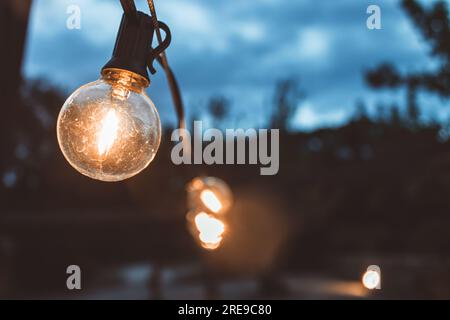 Light bulbs hanging on street Stock Photo