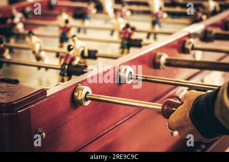 Detail of hands of senior person playing Foosball Stock Photo