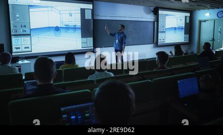 Young Male Teacher Giving a Data Science Lecture to a Diverse Multiethnic Group of Female and Male Students in a Dark College Space. Projecting Slides Stock Photo