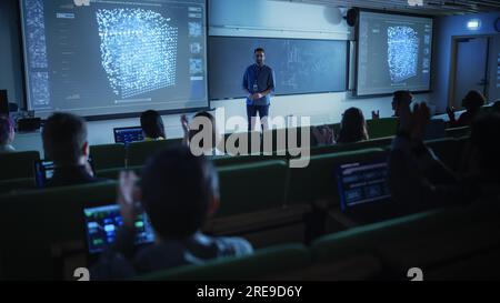 Young Male Teacher Giving a Data Science Lecture to a Diverse Multiethnic Group of Female and Male Students in a Dark College Space. Projecting Slides Stock Photo