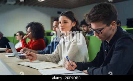 Smart Young Students Studying in University with Diverse Multiethnic Classmates. Scholars Have a Conversation in College Room. Applying Knowledge Stock Photo