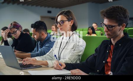 Smart Young Students Studying in University with Diverse Multiethnic Classmates. Scholars Have a Conversation in College Room. Applying Knowledge Stock Photo