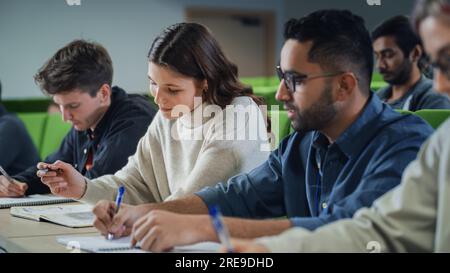Smart Young Students Studying in University with Diverse Multiethnic Classmates. Scholars Have a Conversation in College Room. Applying Knowledge Stock Photo