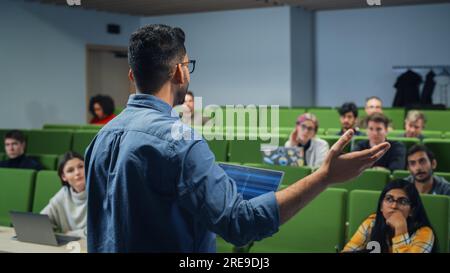 Teacher Giving a Lecture to a Diverse Multiethnic Group of Female and Male Students in Modern College Room. Curious and Thoughtful Scholars Studying Stock Photo