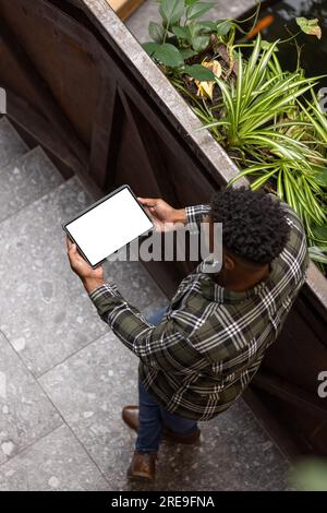 Overhead view of african american man using a digital tablet with copy space on the stairs at office Stock Photo