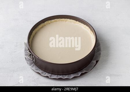 Cheesecake making, metal detachable baking dish with shortcrust pastry for cheesecake or other pie. Step by step, cooking stage, home baking, light gr Stock Photo