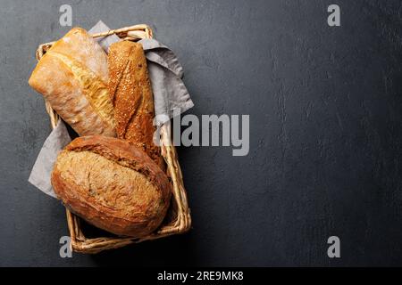 Assorted bread varieties in a charming basket, ready to be enjoyed. Flat lay with copy space Stock Photo