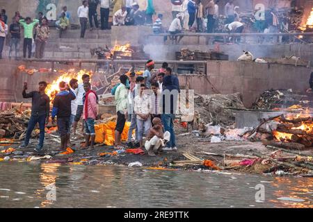 People prepare funeral pyres in Varanasi on the banks of the Ganges, which is one of the oldest continually inhabited cities in the world, and the holiest of the seven sacred cities in Hinduism. Every day at Manikarnika Ghat, the largest and most auspicious cremation ghat, around 100 bodies are cremated on wooden pyres along the river’s edge. The eternal flame that feeds the fires is said to have been burning for centuries now. Varanasi, India. Stock Photo