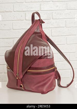 Brown leather backpack bag on white brick background Stock Photo
