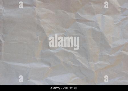 Texture of crumpled craft brown paper, background. Wrinkled parchment pattern. Craft rustic leaf, old packing wrap. Stock Photo