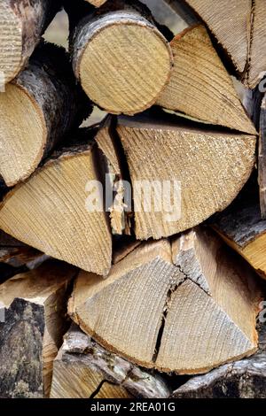 Chopped firewood is stacked in neat piles. Woodpile. Background. Close-up. Selective focus. Stock Photo