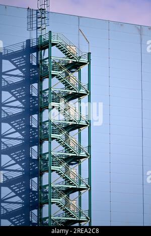 Abstract pattern of zigzag stairs and shadows on the side of a blue building Stock Photo